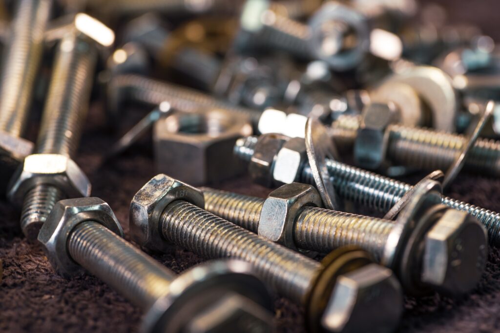 Metal chrome bolts and nuts in a chaotic order industrial background